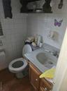 Half bathroom featuring dark wood-type flooring, vanity, tile walls, and backsplash