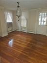 Unfurnished dining area with dark wood-style flooring, baseboard heating, and cooling unit