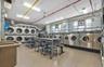 Shared laundry room featuring stacked washer / drying machine, a heating unit, and washing machine and dryer