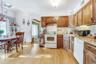 Kitchen featuring white appliances, a skylight, light wood-style flooring, backsplash, and brown cabinets