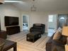 Living room featuring wood finished floors, lofted ceiling, and a baseboard radiator