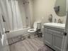Bathroom with vanity, shower / tub combo with curtain, and light wood-style flooring