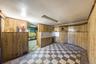 Finished basement with light floors and wood walls