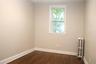 Bedroom with radiator and dark wood-style floors