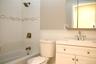 Bathroom featuring vanity, tub / shower combination, tile walls, and decorative backsplash