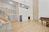 Living room with light wood-type flooring, a towering ceiling, and stairway