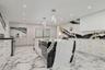 Kitchen with modern cabinets, hanging light fixtures, light stone counters, stainless steel appliances, and a center island
