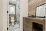 Full bath featuring vanity, a marble finish shower, light marble finish flooring, and tile walls