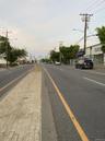 View of asphalt street featuring street lighting, sidewalks, and curbs