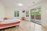 Bedroom with radiator heating unit, access to exterior, and light wood-type flooring