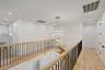Corridor with recessed lighting, a chandelier, light wood-type flooring, and an upstairs landing
