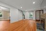 Unfurnished living room with light wood finished floors, recessed lighting, stairway, radiator, and a brick fireplace