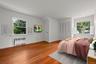Bedroom with radiator heating unit, wood finished floors, and a closet