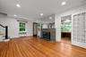 Unfurnished living room featuring stairs, recessed lighting, wood finished floors, radiator, and a brick fireplace