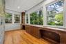 Unfurnished sunroom with built in desk and view of scattered trees
