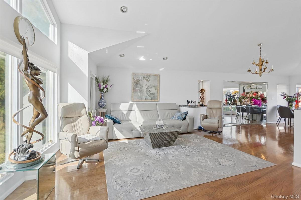 Living room featuring wood finished floors, recessed lighting, a chandelier, and high vaulted ceiling