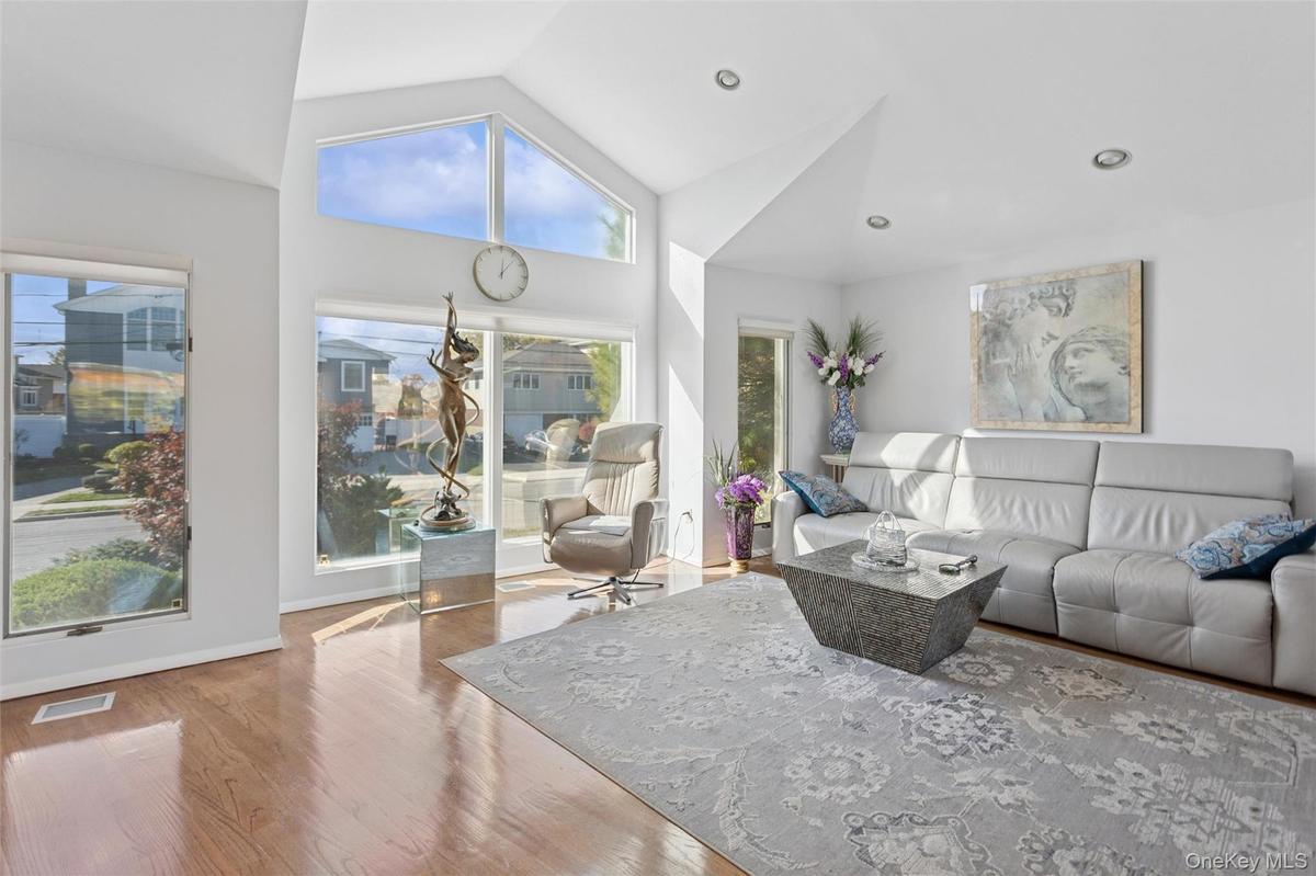Living room featuring wood finished floors, high vaulted ceiling, and recessed lighting