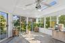 Sunroom featuring healthy amount of natural light, lofted ceiling, stone finish flooring, and a skylight