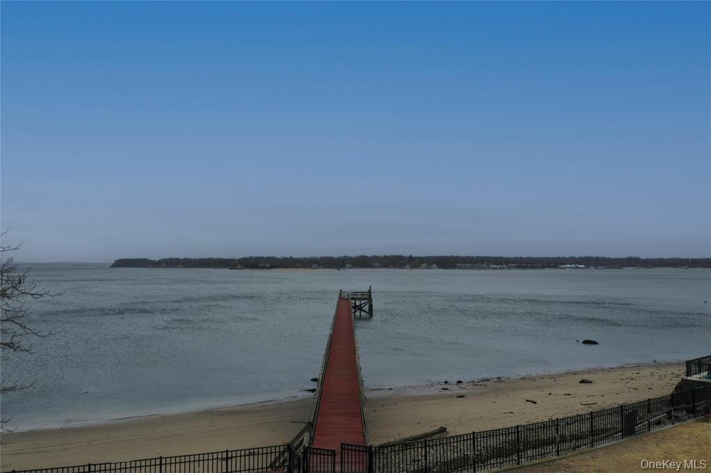Dock with view of water and beach