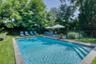 View of pool with a patio and view of scattered trees