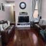 Living room featuring dark wood-style floors and baseboards