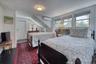 Bedroom featuring dark wood-type flooring and a wall mounted air conditioner