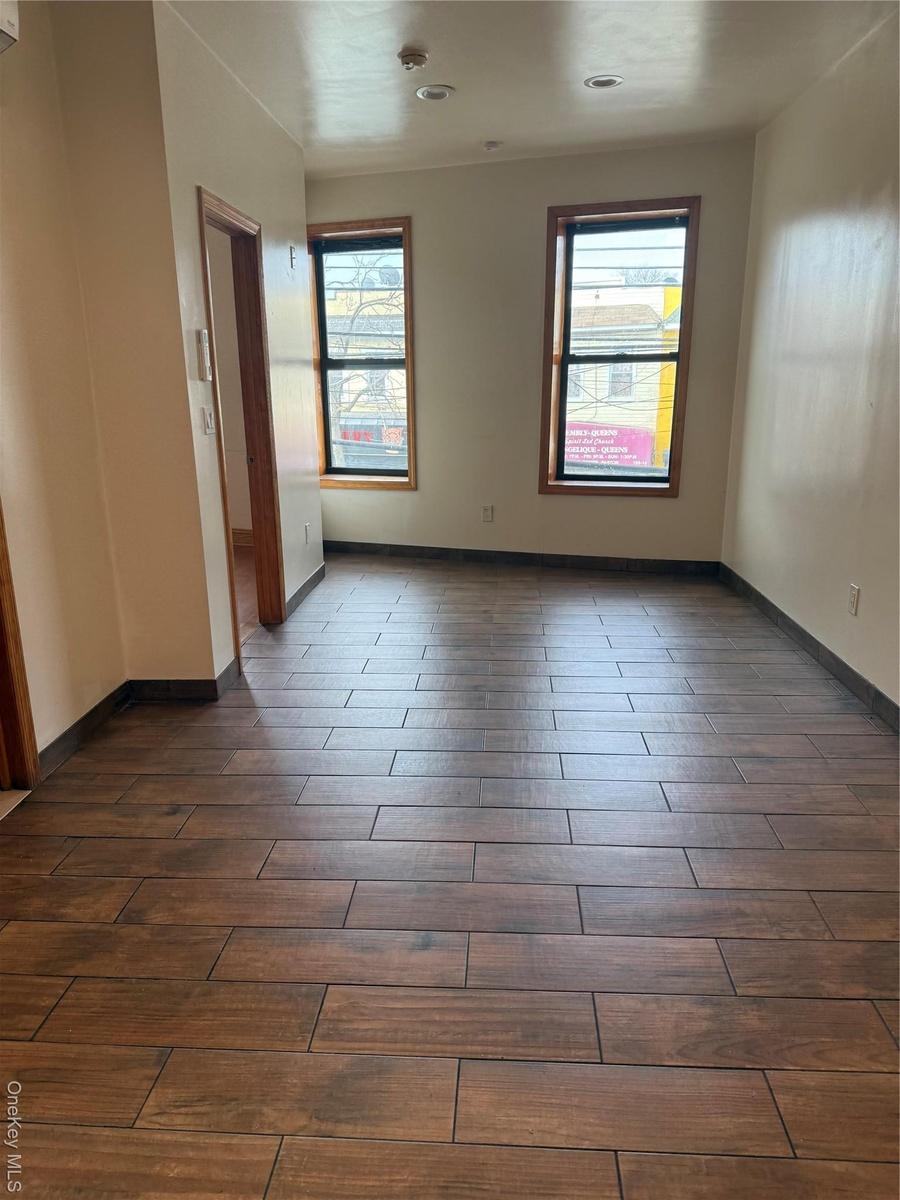 Empty room with plenty of natural light and dark wood-style flooring