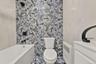 Full bath with a bath, vanity, tile walls, and radiator heating unit
