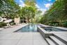 View of pool featuring a patio area, view of scattered trees, and a pool with connected hot tub