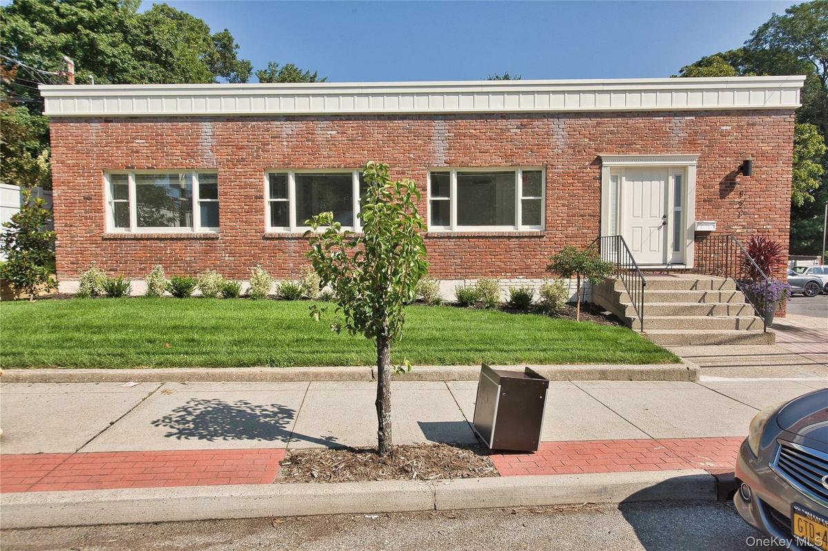 View of front of property featuring brick siding and a front lawn