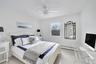 Bedroom featuring light wood-style floors, a ceiling fan, and a baseboard radiator