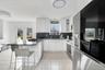 Kitchen featuring appliances with stainless steel finishes, a kitchen bar, a peninsula, decorative backsplash, and white cabinets