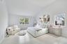 Bedroom featuring wood finished floors, baseboard heating, and high vaulted ceiling