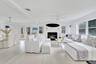 Living area with a glass covered fireplace, light wood-style floors, and ceiling fan
