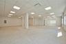 Empty room with a paneled ceiling and electric panel
