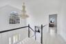 Hallway featuring an upstairs landing, light wood finished floors, vaulted ceiling, and a chandelier