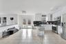 Kitchen with tasteful backsplash, a kitchen breakfast bar, appliances with stainless steel finishes, dark stone countertops, and white cabinets