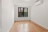 Empty room featuring a wall unit AC and light wood finished floors