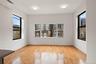 Empty room featuring a wall mounted AC and light wood-style floors