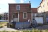 Rear view of property with brick siding and a garage