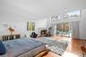 Bedroom featuring multiple windows, access to exterior, light wood finished floors, and a brick fireplace