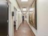Hall featuring a drop ceiling and dark wood-style floors
