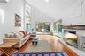 Living room with high vaulted ceiling, wood finished floors, recessed lighting, and a skylight