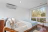 Bedroom with a wall mounted AC, wood finished floors, and recessed lighting
