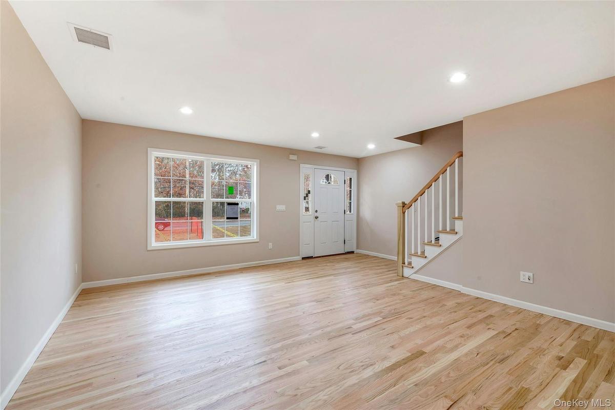 Entryway with stairs, light wood finished floors, and recessed lighting