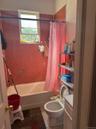 Bathroom featuring shower / bathtub combination with curtain, vanity, and light tile patterned floors
