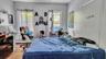 Bedroom with a baseboard heating unit and wood finished floors