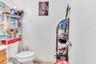 Half bathroom with toilet, tile patterned flooring, and vanity