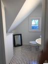 Bathroom with vaulted ceiling, light flooring, and vanity