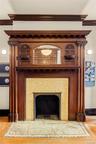Detailed view of wood finished floors, a fireplace, and ornamental molding
